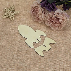 Decorative cutout of a rocket ship on a textured surface with flowers and a star decoration.