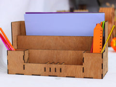 Cardboard desk organizer with stationery items on a white background