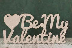 Wooden sign with 'Be My Valentine' on a wooden surface and dark background