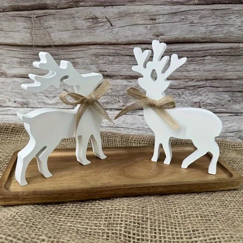 Two white deer figurines with gold bows on a wooden board against a rustic wooden background.