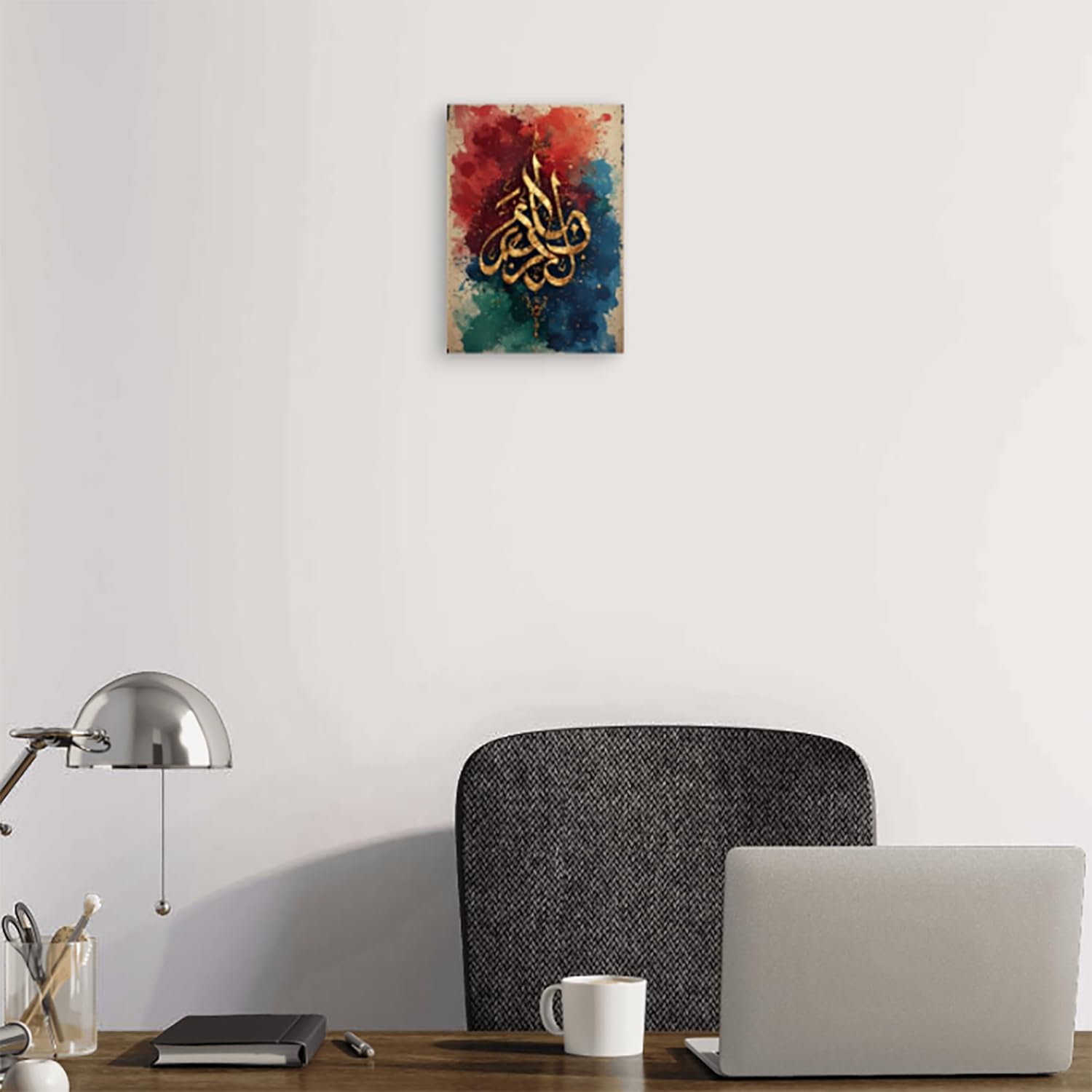 Decorative wall art with colorful abstract design and gold text above a desk with laptop and office supplies.