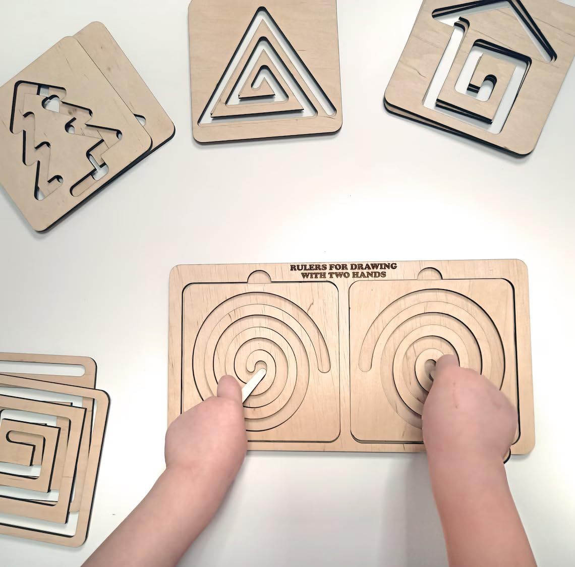 Wooden geometric shapes and a board with circular patterns on a white surface.