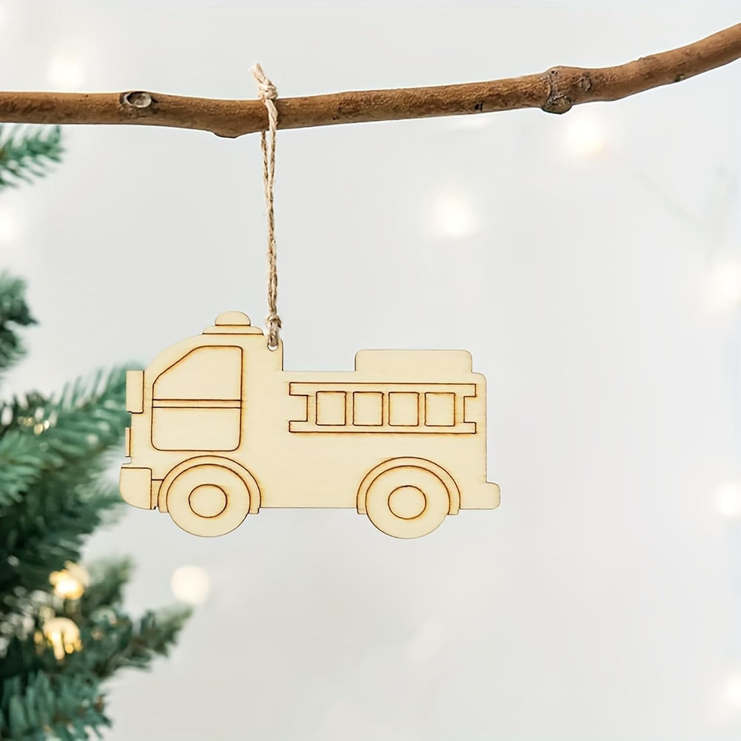 Wooden toy truck ornament hanging on a branch with a blurred Christmas tree background