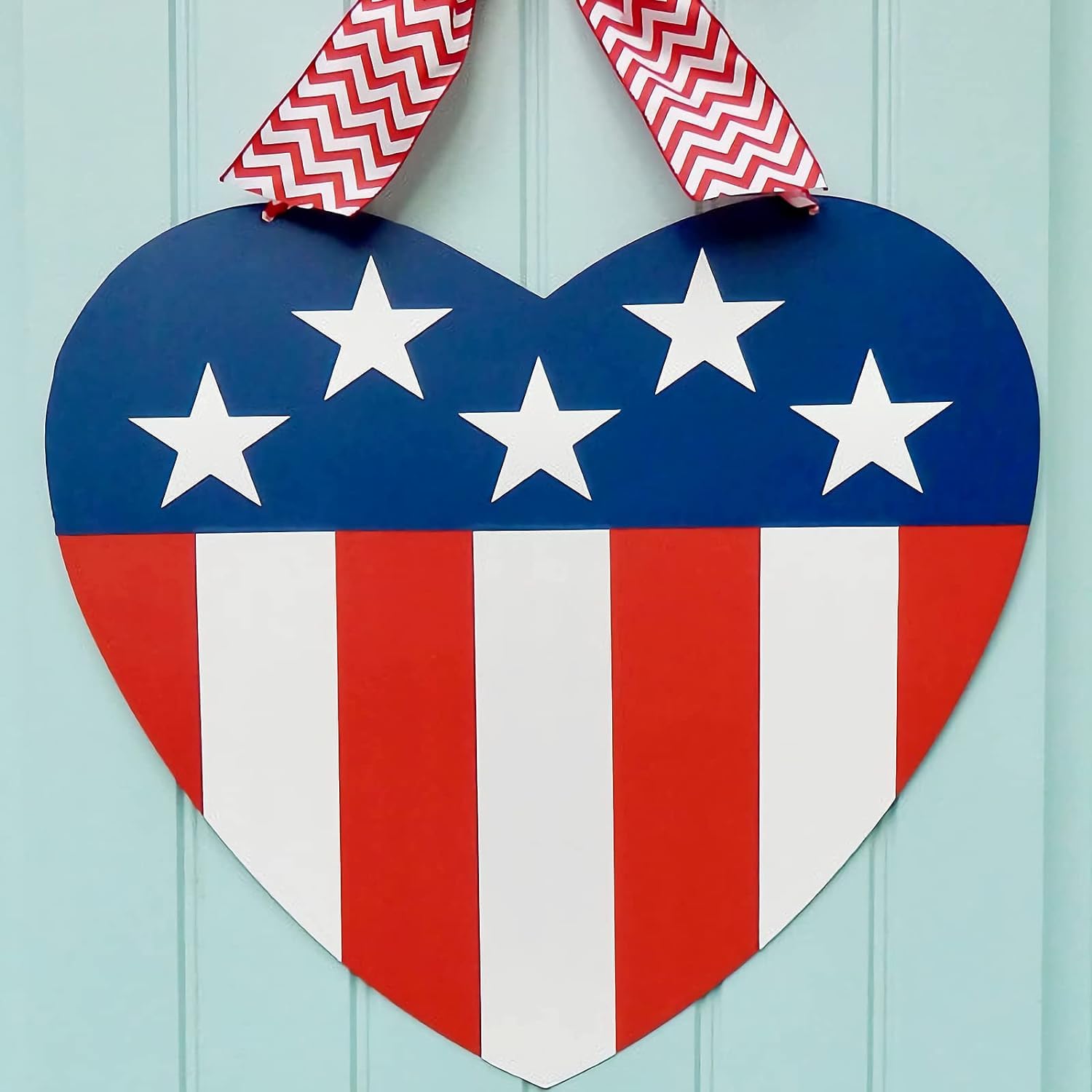 Heart-shaped patriotic decoration with stars and stripes on a light blue background