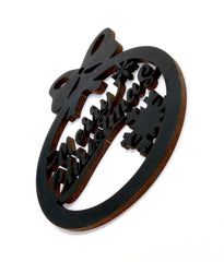 Decorative wooden brooch with intricate cut-out design on a white background