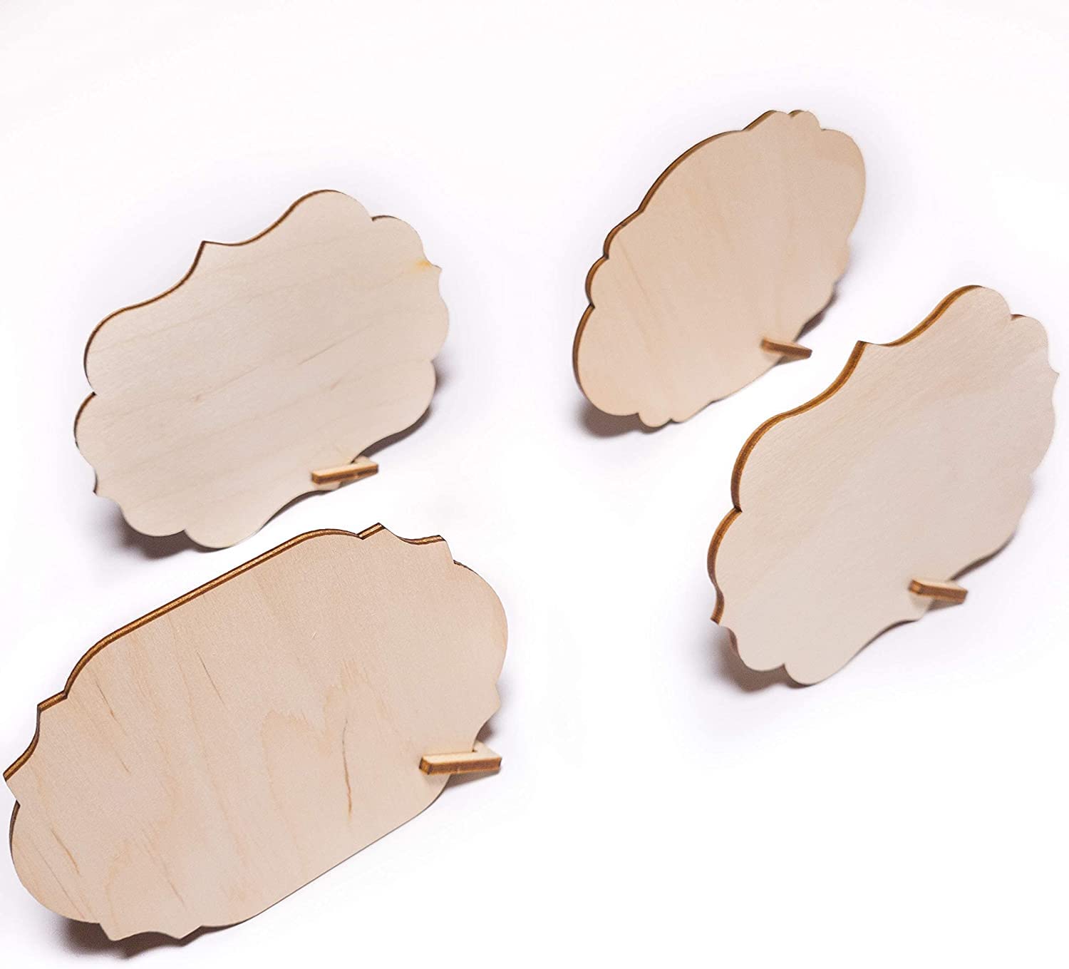 Four wooden coasters with scalloped edges on a white background