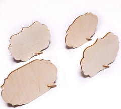 Four wooden coasters with scalloped edges on a white background