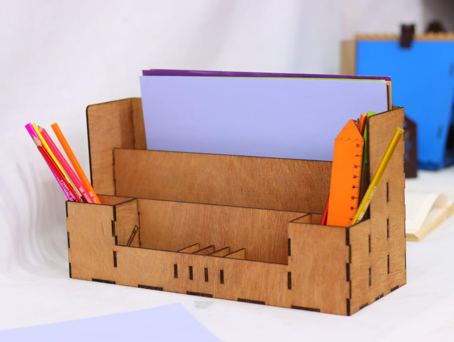 Cardboard desk organizer with stationery items on a white background