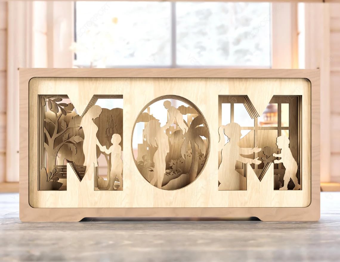 Wooden decorative piece with cut-out silhouettes and 'MOM' text on a wooden surface.