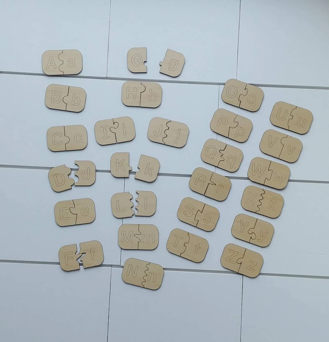 Wooden puzzle letters scattered on a tiled floor