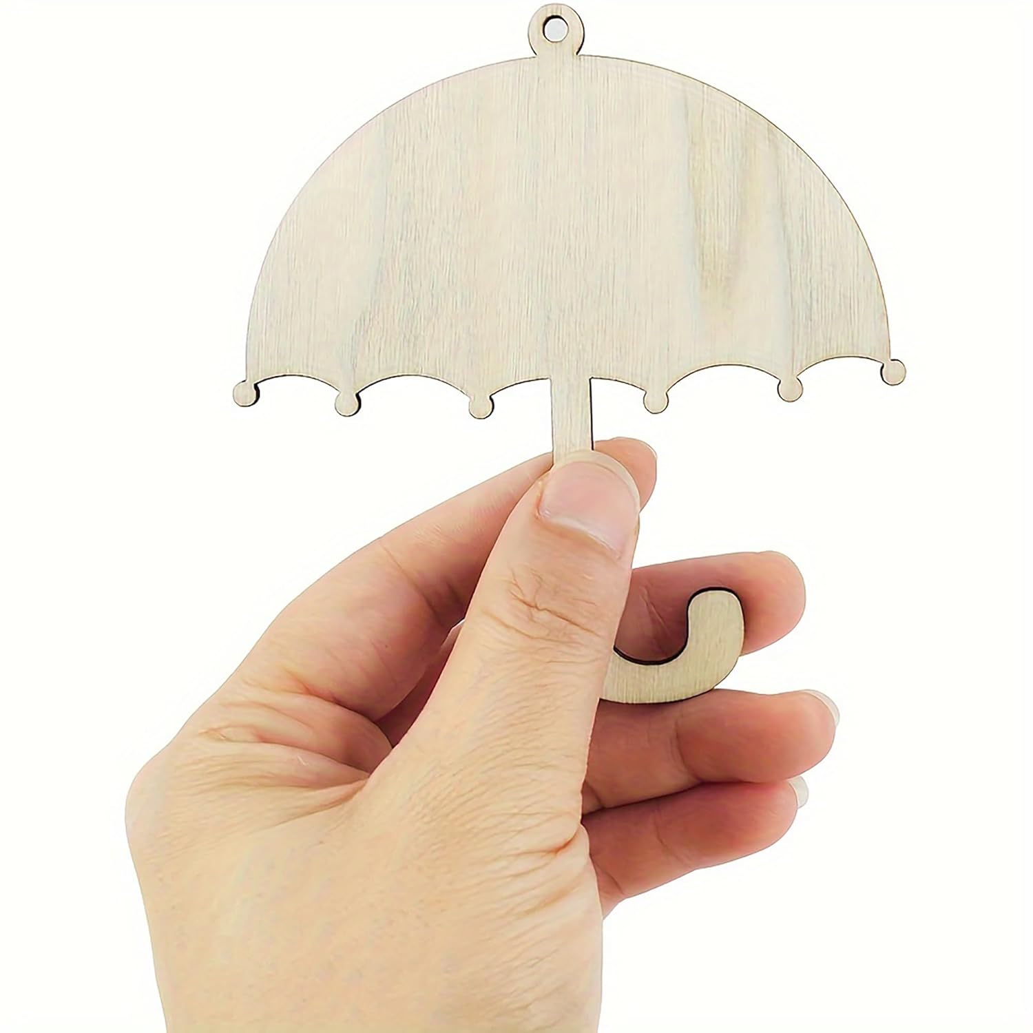 Wooden umbrella-shaped ornament held by a hand against a white background