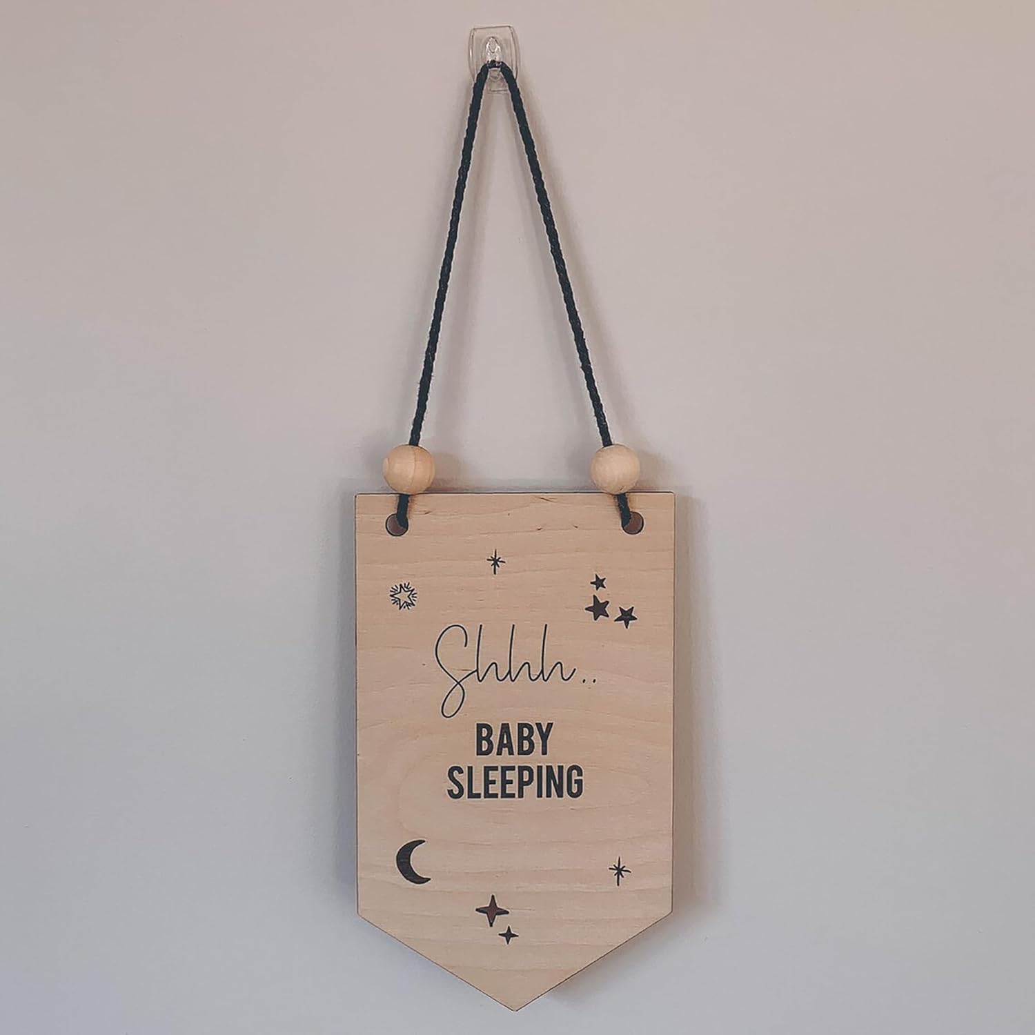 Wooden sign with 'Shhh... Baby Sleeping' text and decorative elements on a plain background