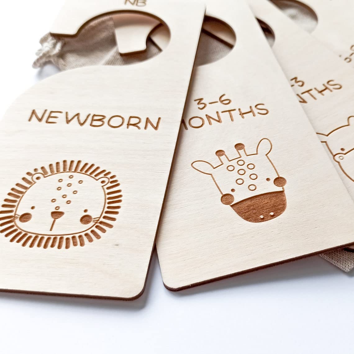 Wooden baby size dividers with lion and giraffe illustrations and text for newborn to 3-6 months.