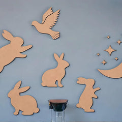 Wooden cutouts of rabbits, a bird, and stars on a blue wall.