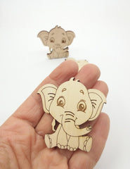 Wooden elephant cutout held in a hand with a plain background