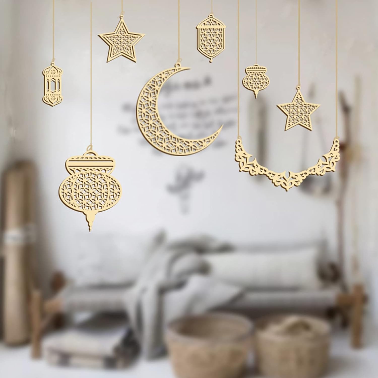 Decorative gold moon and star ornaments hanging against a blurred indoor background.