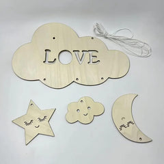 Wooden cloud-shaped decoration with 'LOVE' letters, star, cloud, and moon shapes on a light gray background.
