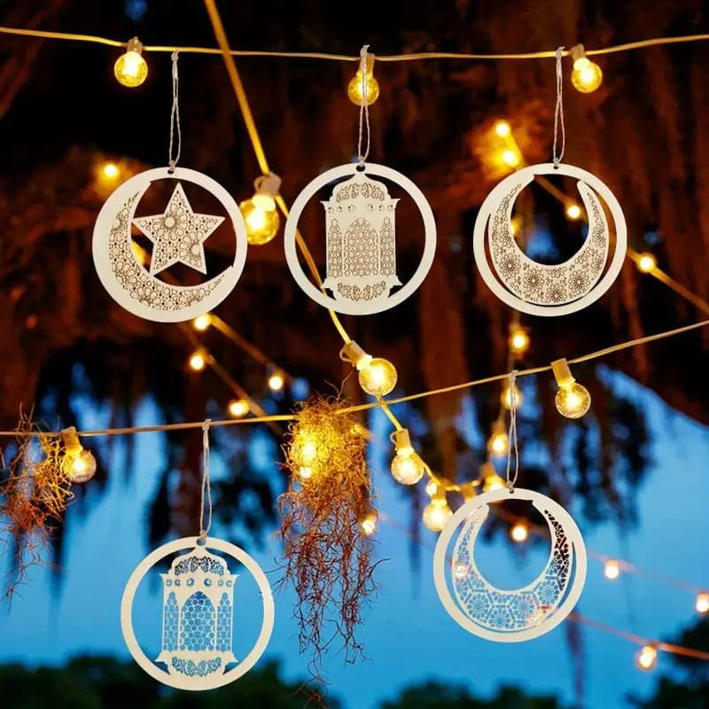 Decorative hanging items with star, moon, and architectural design against a string of lights.