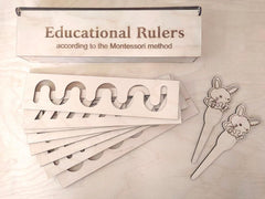 Educational rulers according to the Montessori method on a wooden surface with rabbit-themed handles.