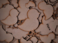 Wooden cutouts of chickens scattered on a dark background