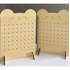 Two wooden pegboards with cat face designs on a plain background