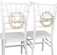 Two white chairs with 'brides' and 'groom' signs on a white background