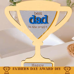 Gold trophy-shaped award with 'best dad in the world' text on a neutral background
