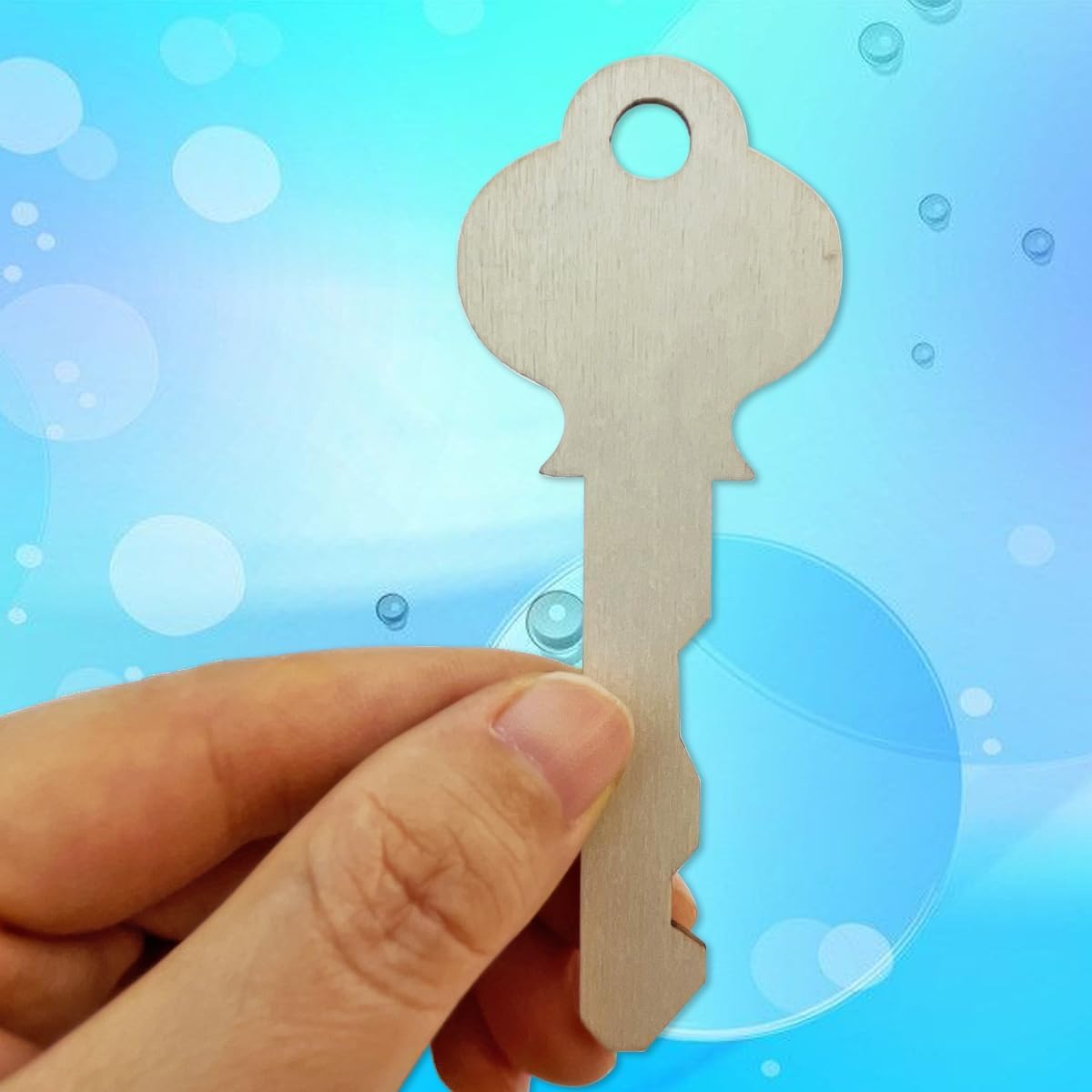 Hand holding a key-shaped object against a blue bubble background