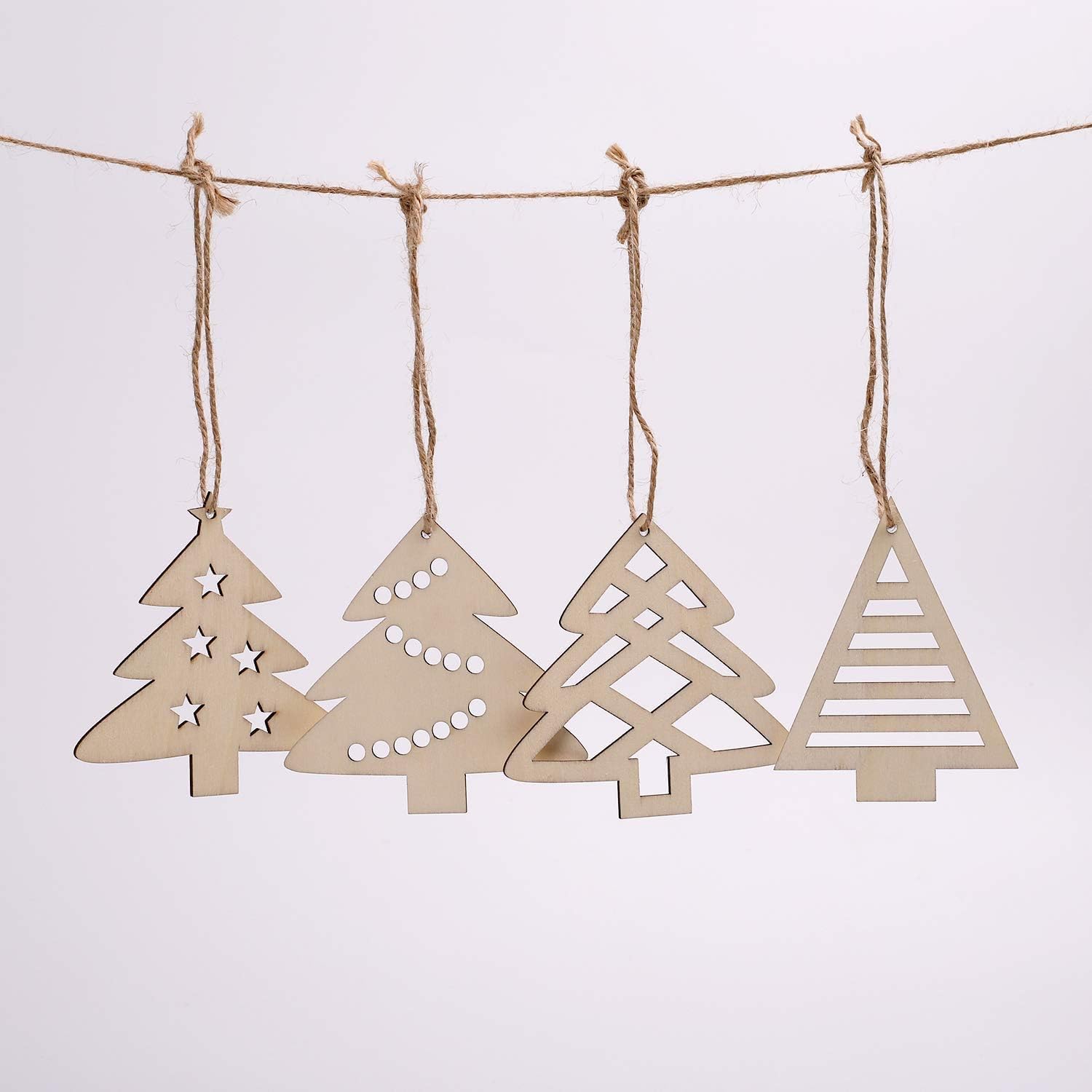 Set of wooden Christmas tree ornaments hanging on a string against a light background