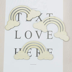 Decorative cutouts of rainbows and clouds on a paper with text