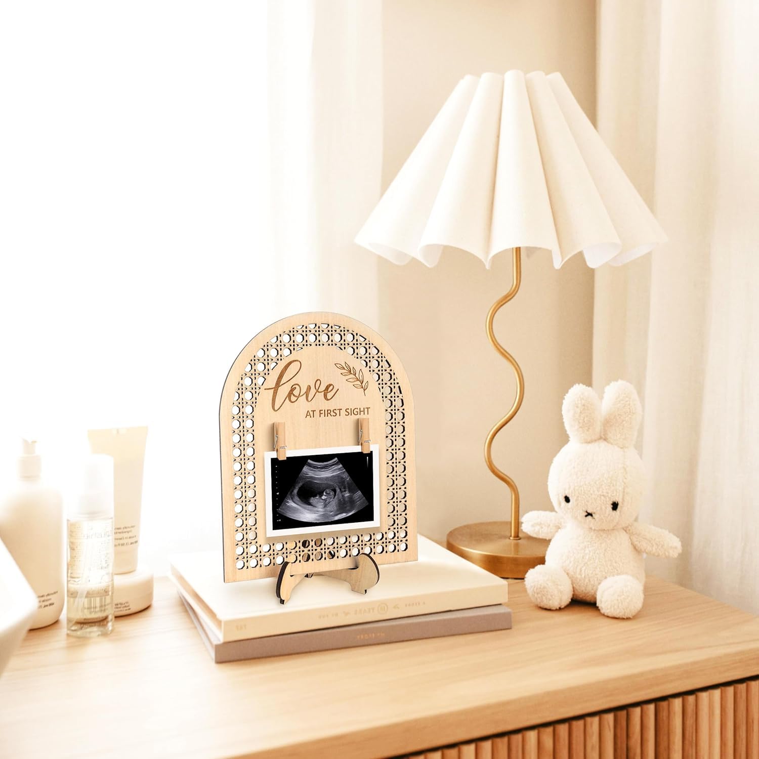 Decorative ultrasound frame on a table with a lamp and plush toy in the background