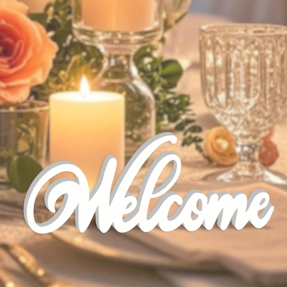 Decorative 'Welcome' sign on a table with candles and flowers