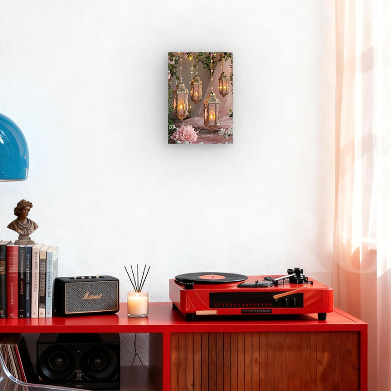 Red record player on a wooden shelf with books, a candle, and a small statue.