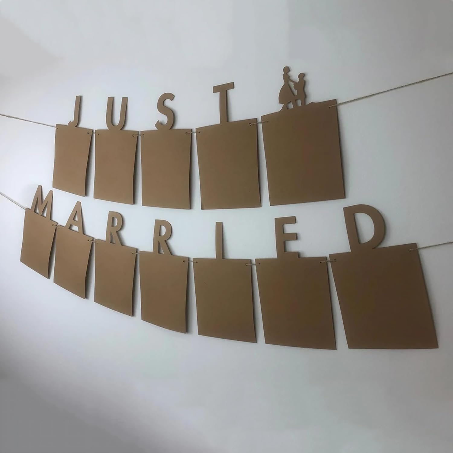 Brown paper 'Just Married' banner with a couple silhouette on a white background