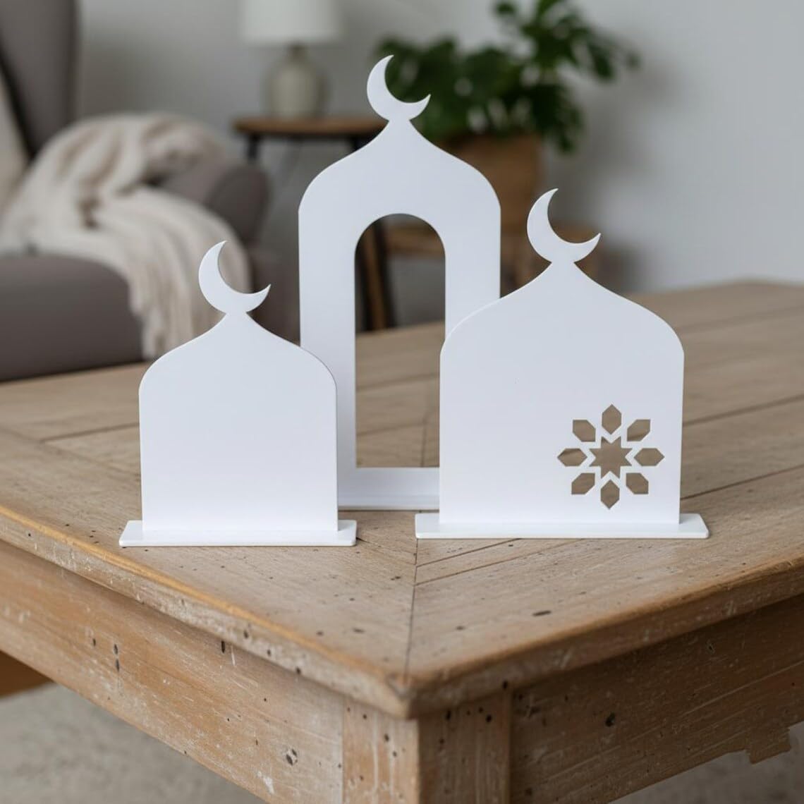Decorative white metal bookends with crescent moon design on a wooden surface.