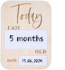 Wooden baby milestone board with 'Today I am 5 months old' text and date placeholder.