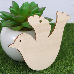 Wooden dove ornament with a succulent plant in the background