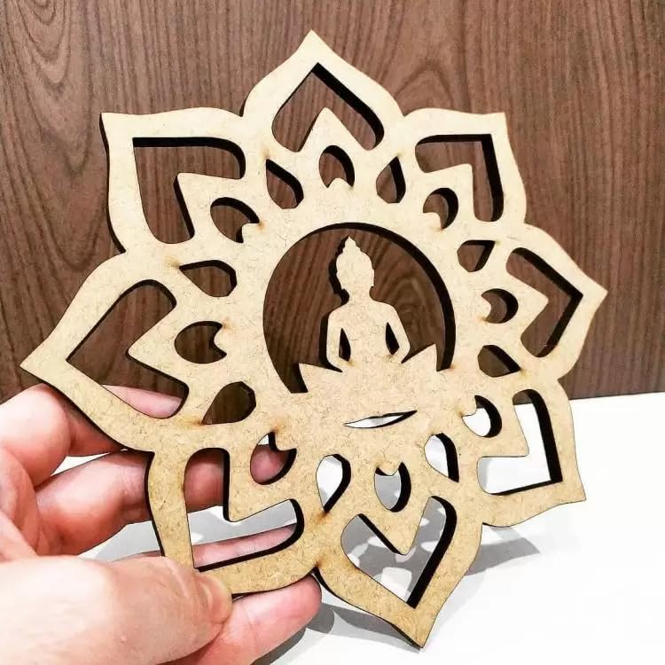 Decorative wooden cutout with Buddha silhouette in a mandala design held by a hand against a wooden background.