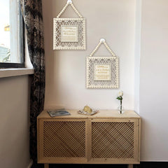 Wooden cabinet with decorative items against a wall with framed art.