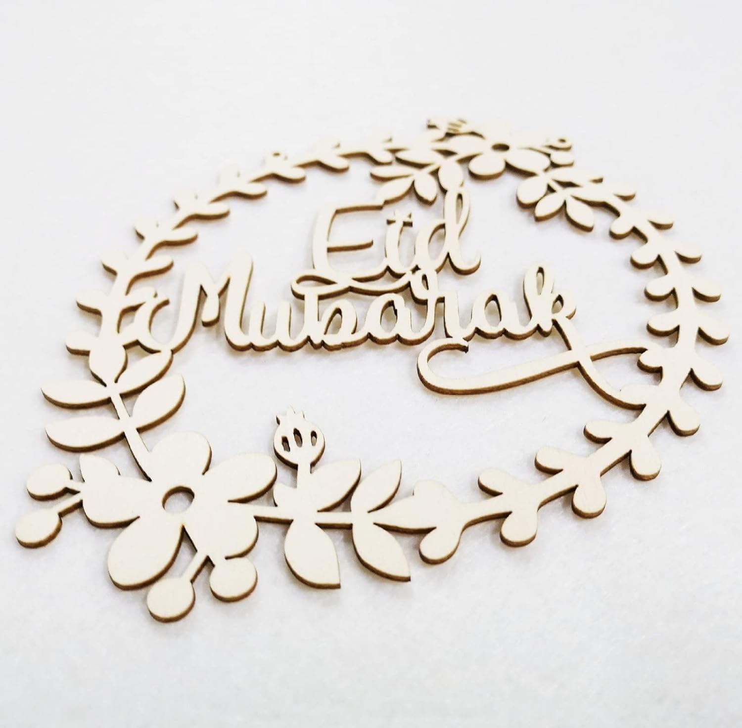 Wooden wreath with 'Eid Mubarak' text on a white background