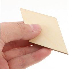 Hand holding a small beige square piece of paper against a white background
