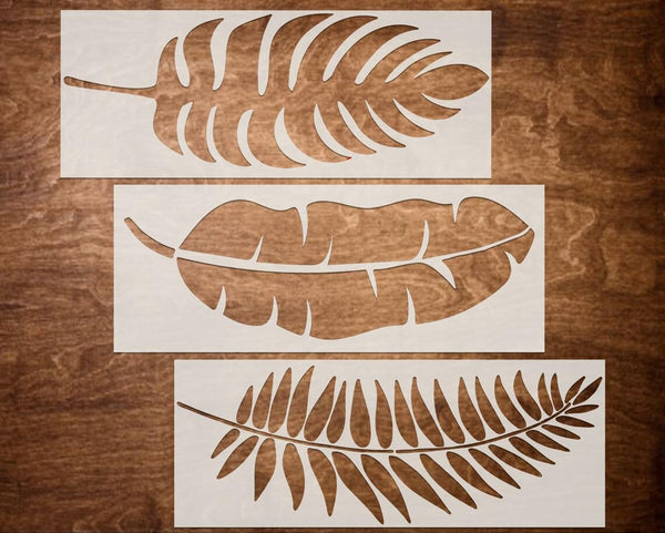 Three leaf-shaped stencils on a wooden surface