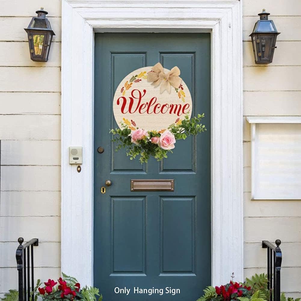 Decorative 'Welcome' sign with flowers and a bow on a teal door.
