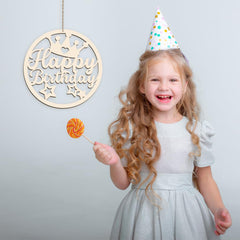 Child wearing a party hat with a 'Happy Birthday' decoration and a lollipop.