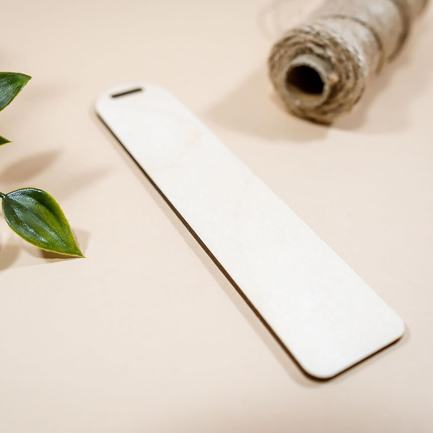 Phone case on a beige surface with a leaf and roll of twine