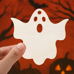 Hand holding a white ghost-shaped cutout against a Halloween-themed background with pumpkins.