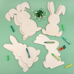 Wooden bunny shapes with markers on a green background