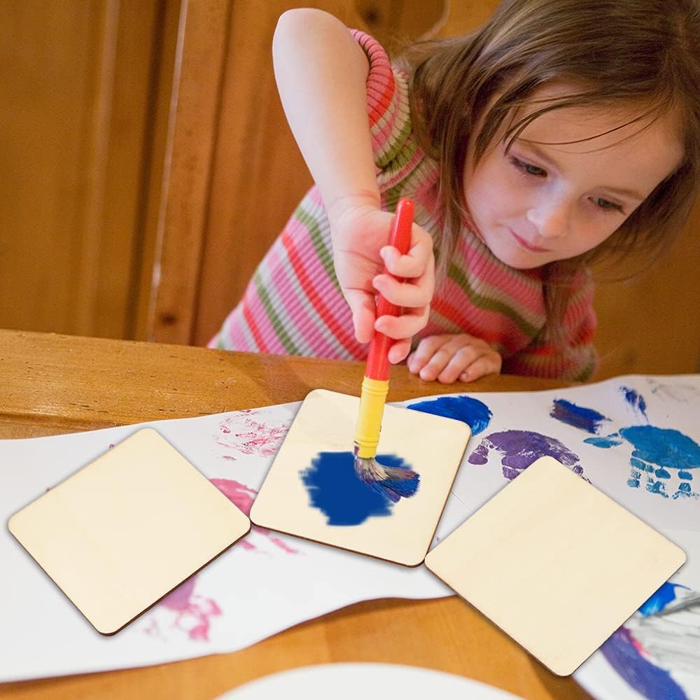 Child painting on a wooden table with colorful paint