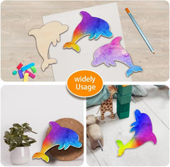 Colorful dolphin-shaped cutouts on a wooden surface with a pencil, surrounded by various items.