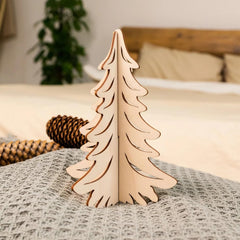 Wooden Christmas tree decoration on a bed with pine cones and a plant in the background